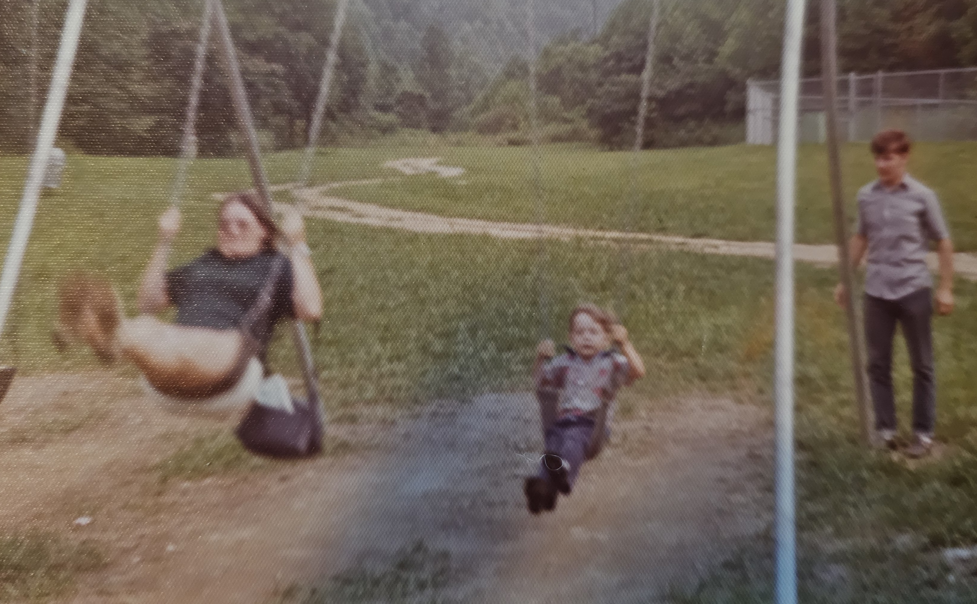 Caroline, a child, and Gary playing on swings